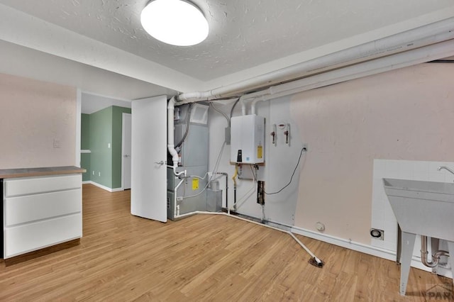 452 S Siesta Ln, Pueblo West, CO 81007 - below grade area featuring tankless water heater, wood finished floors, and heating unit