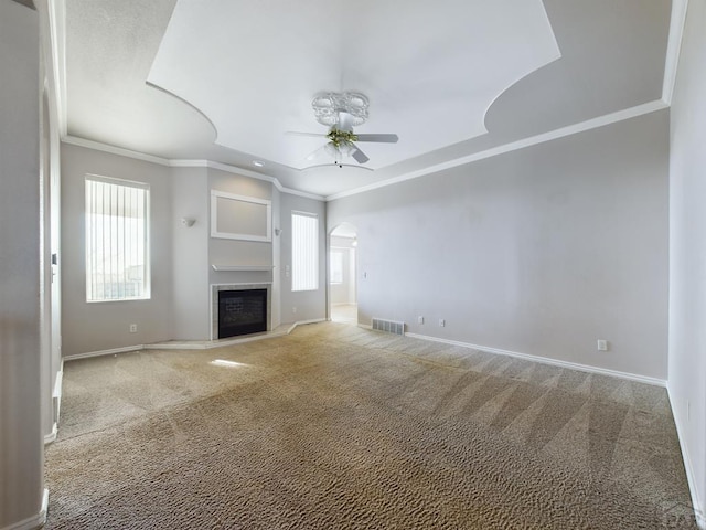 unfurnished living room featuring arched walkways, carpet flooring, ceiling fan, and visible vents