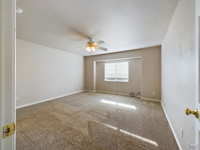 unfurnished room with carpet, baseboards, and a ceiling fan