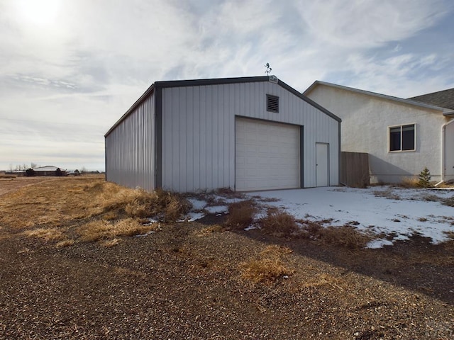 snow covered garage featuring a garage