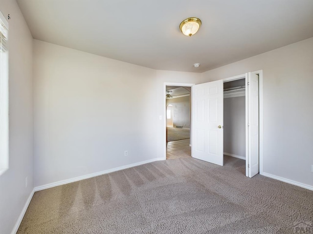 unfurnished bedroom featuring a closet, carpet flooring, and baseboards