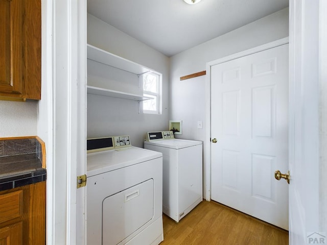 washroom with laundry area, light wood-style floors, and washer and dryer