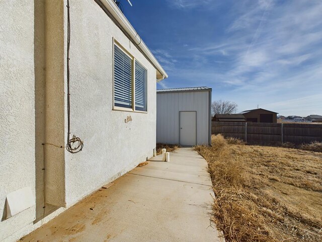 view of home's exterior with fence and stucco siding