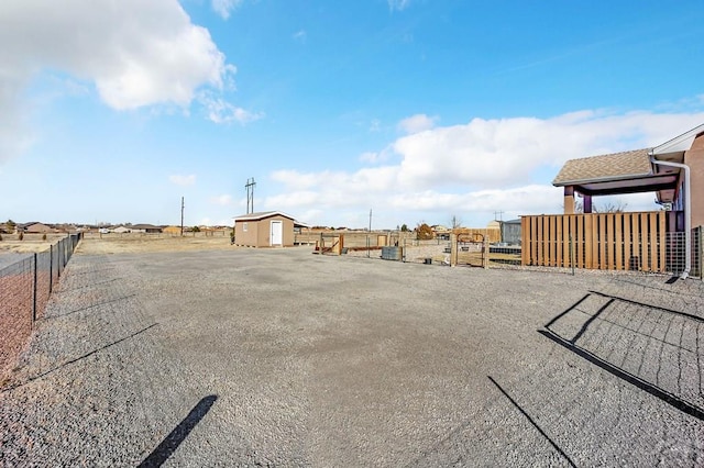 view of yard with an outdoor structure, fence, and a shed