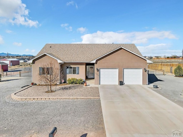 ranch-style house featuring stucco siding, driveway, a garage, and fence