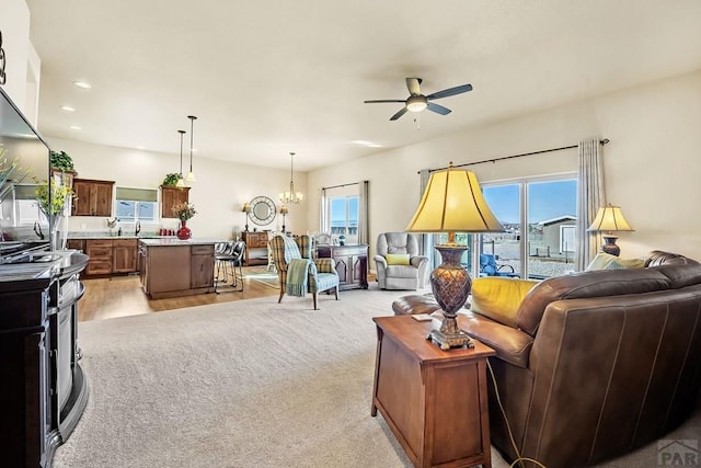 living room featuring a wealth of natural light, recessed lighting, ceiling fan with notable chandelier, and light carpet