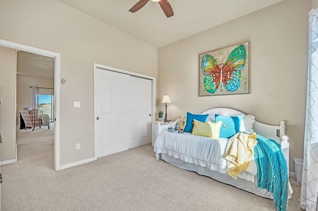 carpeted bedroom with a closet, a ceiling fan, baseboards, and vaulted ceiling