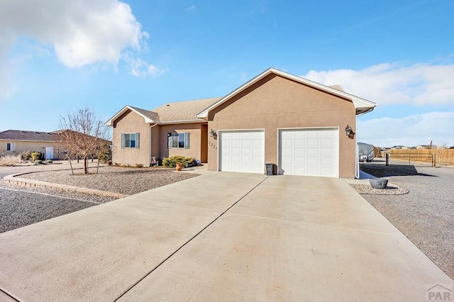 single story home with stucco siding, concrete driveway, a garage, and fence