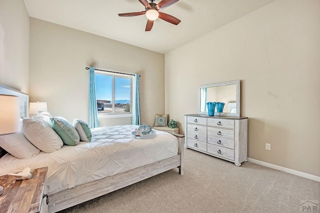 bedroom featuring light colored carpet, a ceiling fan, and baseboards