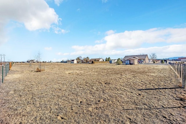 view of yard featuring a rural view and fence