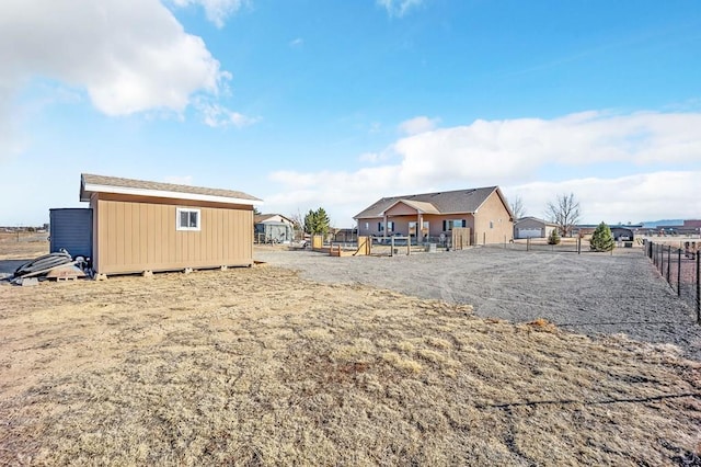 view of yard featuring an outdoor structure, a storage unit, and fence