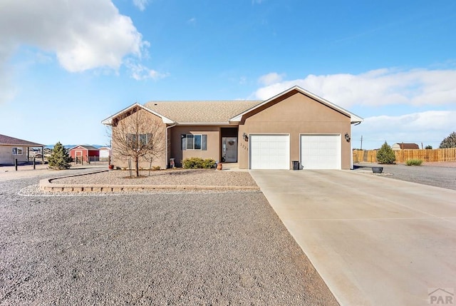 single story home with stucco siding, concrete driveway, a garage, and fence