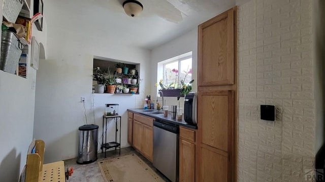 kitchen with dark countertops, brown cabinets, dishwasher, and a sink