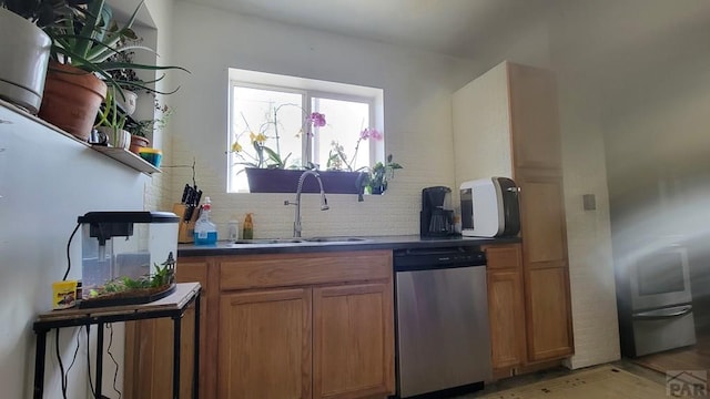 kitchen with a sink, dark countertops, dishwasher, and brown cabinets