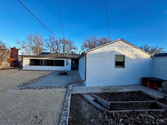 rear view of house with a patio and stucco siding