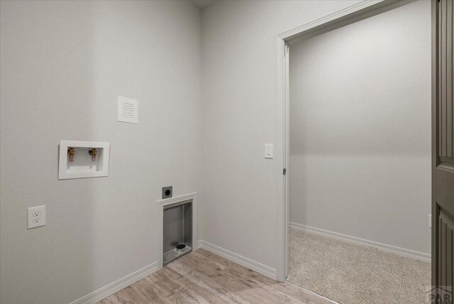 clothes washing area with hookup for a washing machine, light wood-style flooring, hookup for an electric dryer, laundry area, and baseboards