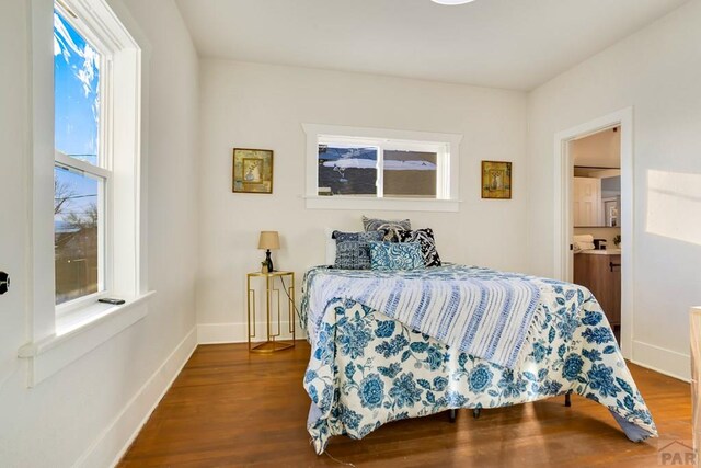 bedroom with baseboards and wood finished floors