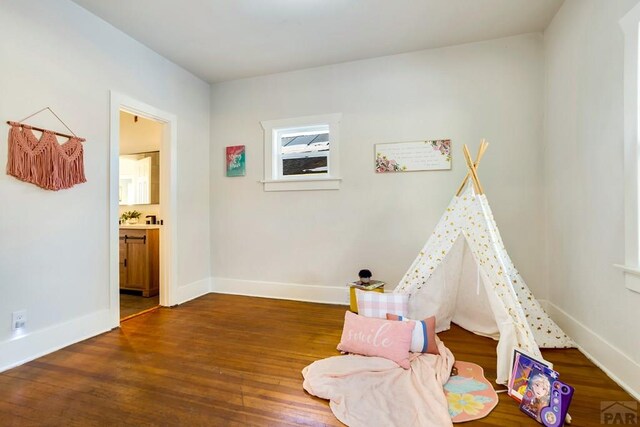 playroom featuring dark wood finished floors and baseboards