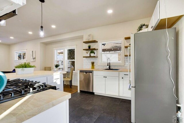 kitchen featuring white cabinets, hanging light fixtures, freestanding refrigerator, dishwasher, and open shelves