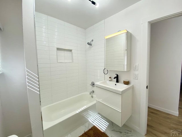 bathroom featuring baseboards, shower / washtub combination, and vanity