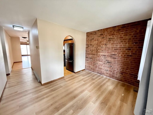 2302 Cartier Dr Unit A, Pueblo, CO 81005 - spare room with brick wall, arched walkways, and light wood finished floors