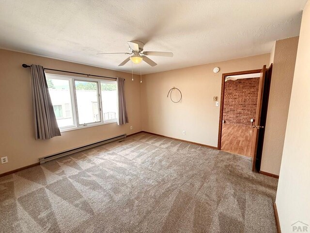 2302 Cartier Dr Unit A, Pueblo, CO 81005 - spare room featuring baseboard heating, carpet floors, ceiling fan, and a textured ceiling