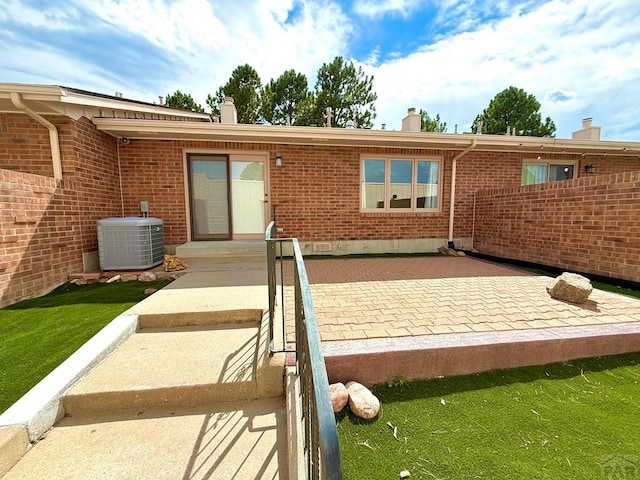 2302 Cartier Dr Unit A, Pueblo, CO 81005 - rear view of property featuring a chimney, brick siding, and a patio