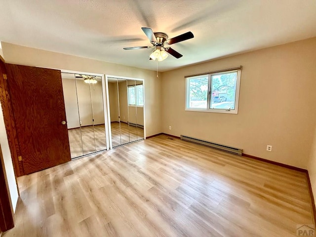 2302 Cartier Dr Unit A, Pueblo, CO 81005 - unfurnished bedroom featuring a baseboard radiator, two closets, wood finished floors, and a ceiling fan