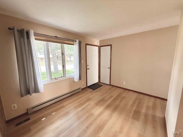 2302 Cartier Dr Unit A, Pueblo, CO 81005 - unfurnished room featuring a baseboard heating unit and light wood-style floors