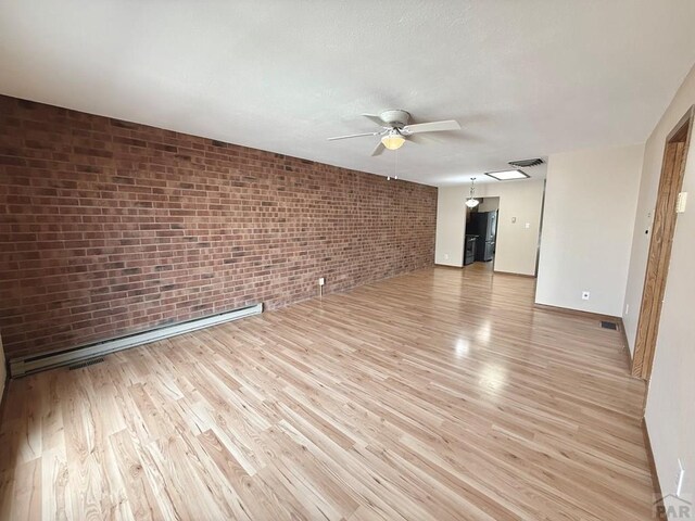 2302 Cartier Dr Unit A, Pueblo, CO 81005 - empty room with a ceiling fan, brick wall, light wood finished floors, and baseboard heating