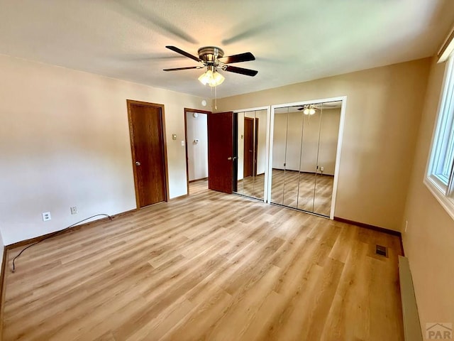 2302 Cartier Dr Unit A, Pueblo, CO 81005 - unfurnished bedroom with multiple closets, baseboard heating, wood finished floors, and ceiling fan