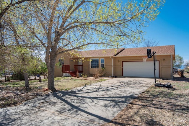 ranch-style home featuring a garage, stucco siding, and driveway
