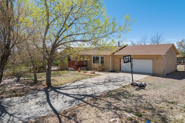 single story home featuring an attached garage, driveway, and stucco siding