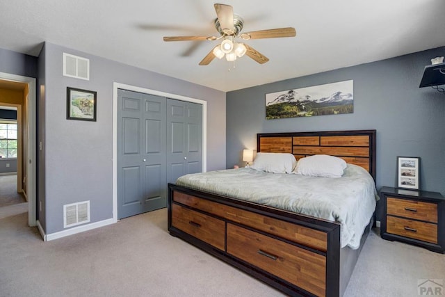 bedroom with visible vents, baseboards, a closet, and light carpet