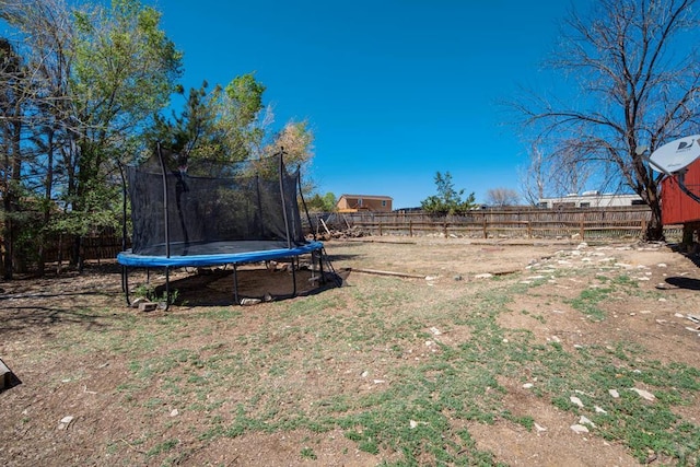 view of yard with a fenced backyard and a trampoline