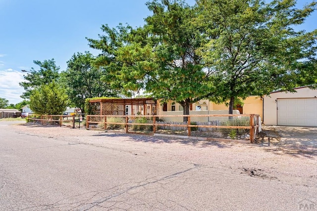 view of front of property with a garage, a fenced front yard, and stucco siding