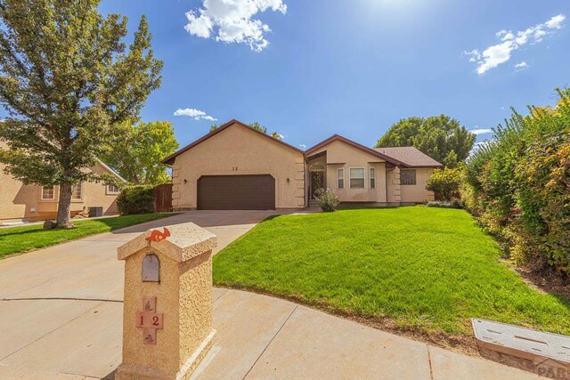 view of front of home featuring driveway, stucco siding, a garage, and a front yard