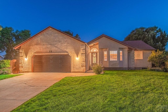 view of front of property featuring a front yard, driveway, an attached garage, and stucco siding