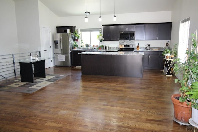 1470 Villa Spanada, Pueblo, CO 81006 - kitchen with stainless steel appliances, a center island, hanging light fixtures, dark wood-style flooring, and high vaulted ceiling