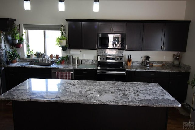 1470 Villa Spanada, Pueblo, CO 81006 - kitchen with appliances with stainless steel finishes, a sink, a center island, and light stone countertops