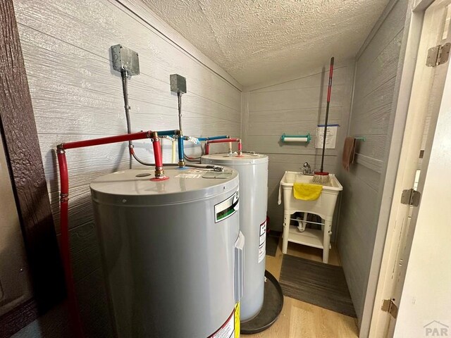 utility room with water heater and a sink