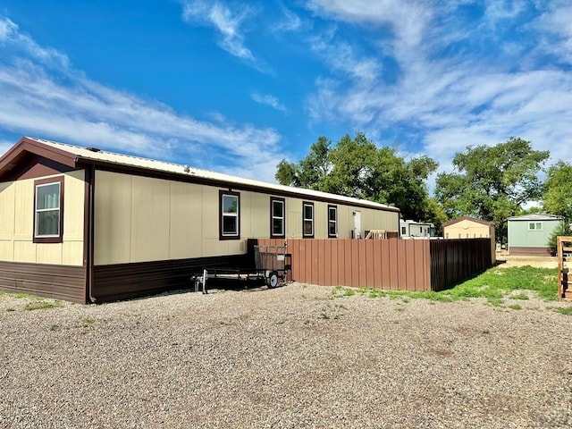 back of property with fence and metal roof