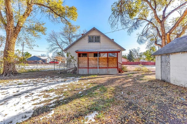 rear view of house featuring fence