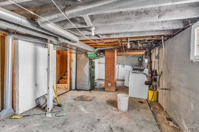 unfinished below grade area featuring heating unit and washer and dryer