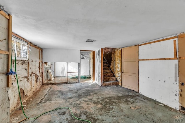 empty room with visible vents and stairway