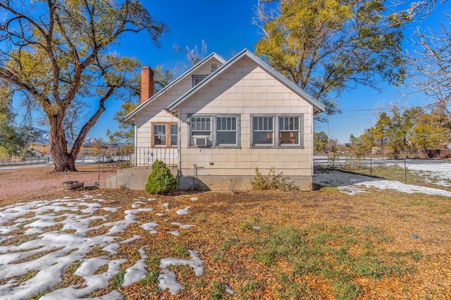 view of property exterior featuring a chimney and cooling unit