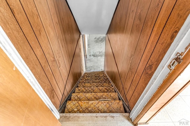 staircase featuring wood walls