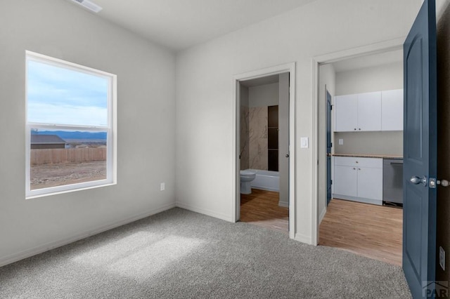 280 W Harmony Dr, Pueblo West, CO 81007 - unfurnished bedroom featuring light colored carpet, ensuite bath, and baseboards
