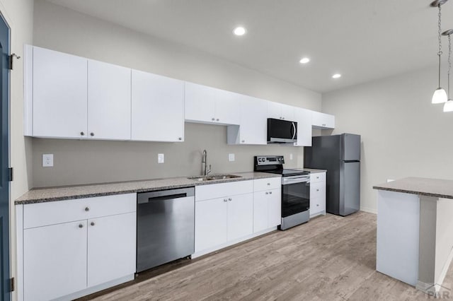 280 W Harmony Dr, Pueblo West, CO 81007 - kitchen featuring a sink, pendant lighting, white cabinetry, appliances with stainless steel finishes, and light wood-style floors