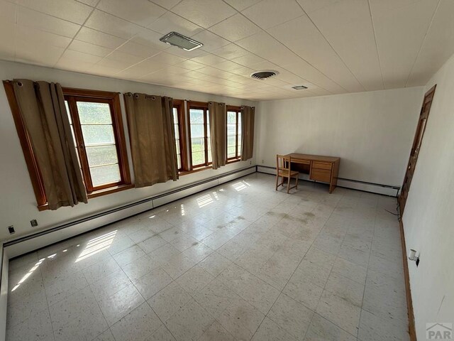 480 W 9th Ave, Lamar, CO 81073 - spare room featuring plenty of natural light, light floors, a baseboard radiator, and baseboards